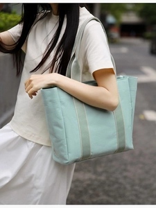 Minimalist mint green canvas tote bag with decorative straps for stylish daily commuting