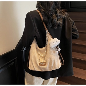 Détail du sac cabas beige avec chaîne de perles et breloque nuage en peluche