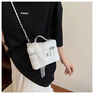 Gros plan détaillé du sac bandoulière matelassé blanc avec perles et chaîne argentée