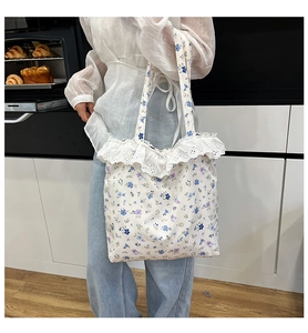 Detail of floral canvas tote bag with delicate white lace trim and blue flower patterns