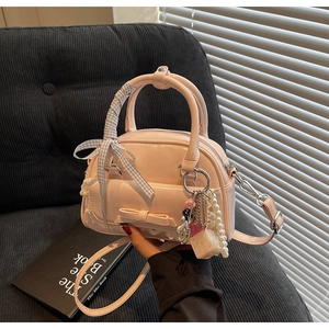 Pink bowling bag detail with lace, bow decoration and black-white checkered ribbon handle