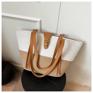 Dettaglio della borsa tote intrecciata con cuciture bicolore e spallacci in pelle