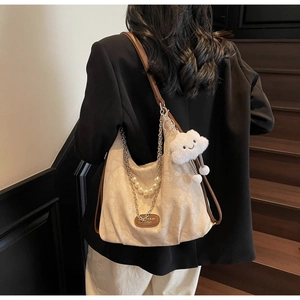 Détail du sac plissé blanc cassé avec chaîne en perles et breloque nuage en peluche