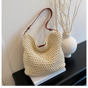 Detail of hand-woven beige crochet hobo bag with adjustable brown leather shoulder strap