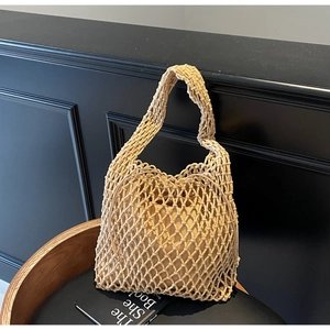 Detail of hand-woven hollow bucket bag featuring beige cord texture and inner pouch