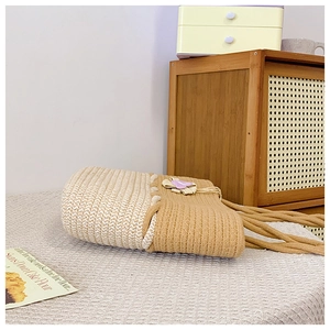 Détail du sac cabas tissé bicolore avec fleurs violettes et poignées en corde épaisse