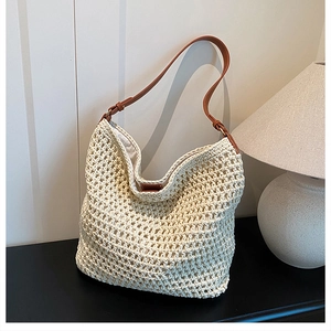 Detailed close-up of the woven hollow mesh texture and brown leather strap on the hobo bag