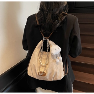 Détail du sac beige texturé avec chaîne de perles, lanières brunes et pendentif nuage