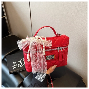 Détail du sac mallette matelassé rouge avec chaîne perles et nœud en dentelle
