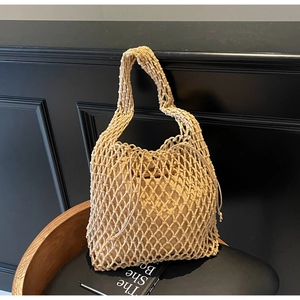 Close-up of beige woven bucket bag featuring diamond mesh texture and drawstring pouch