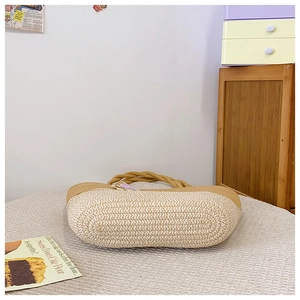 Détail d'un sac en paille bicolore avec motifs tissés beige et marron pour femme