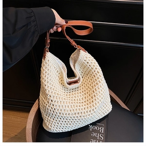 Detail of hand-woven straw tote bag with brown leather straps for summer beach vacation