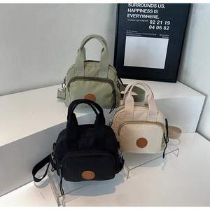 Detailansicht von drei wasserdichten Nylon-Umhängetaschen in Grün, Beige und Schwarz