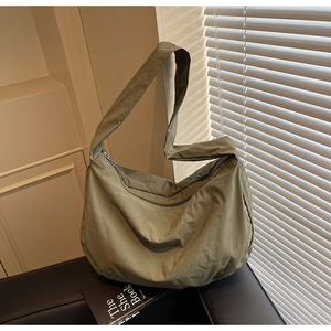 Détail du sac hobo en nylon vert olive montrant la texture légère et la bandoulière large