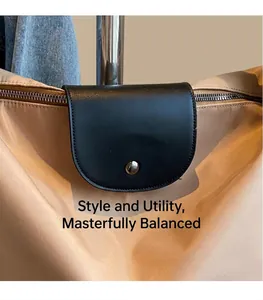 Detail of nylon tote bag featuring black leather flap with silver metal snap button closure