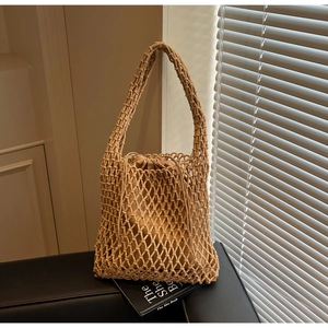 Detail of woven mesh shoulder bag with interior drawstring pouch and light shadows