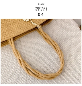 Detailed close-up of woven rope handle on ginger straw tote bag for beach vacations