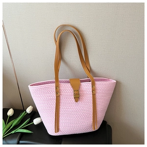 Dettaglio della trama rosa della borsa tote con cinturino in pelle marrone e fibbia