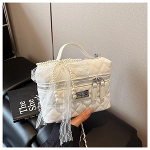 Détail du sac à main matelassé blanc avec nœud en dentelle, perles et fermoir argenté