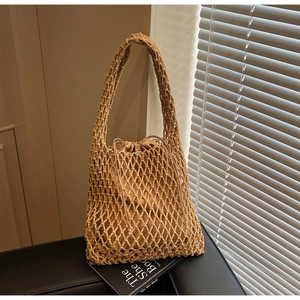 Detail of beige woven bucket bag with mesh pattern and drawstring canvas inner pouch
