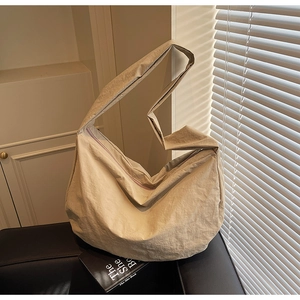 Détail du sac bandoulière en nylon beige montrant la texture plissée et la sangle