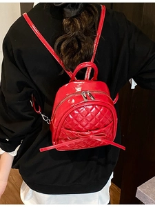 Mini sac à dos rouge matelassé avec nœud porté par un mannequin pour la taille