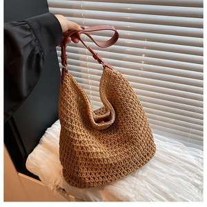 Detailed macro of the woven texture and dark brown leather strap on a caramel hobo bag