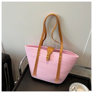 Dettaglio della borsa mare rosa intrecciata con manici in ecopelle marrone e rivetti