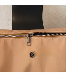 Detail of premium metal magnetic buckle and zipper closure on beige oxford tote bag
