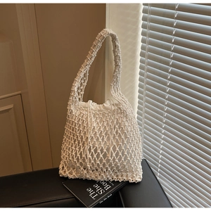 Detail of white hand-woven mesh bucket bag with a canvas drawstring inner pouch