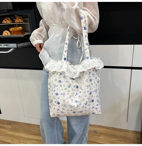 Close-up of floral canvas tote bag featuring delicate white lace ruffle trim details