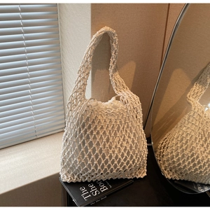 Detailed close-up of a white woven macramé bucket bag with a drawstring inner pouch