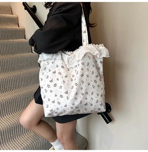 Detail of floral canvas tote bag featuring delicate white lace trim and feminine ruffles