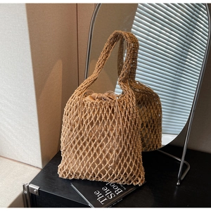 Detail shot of a beige woven bucket bag featuring diamond mesh and drawstring lining