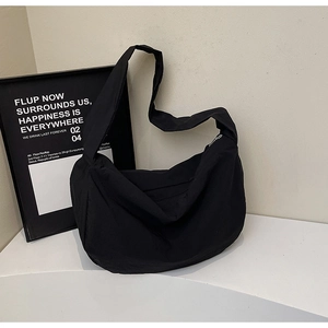 Détail du sac bandoulière croissant en nylon noir avec grande capacité et texture souple
