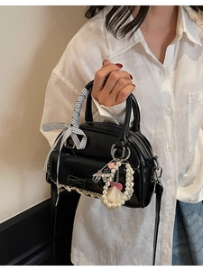 Minimalist black patent bowling bag with lace trim and bow accent for sweet vintage style