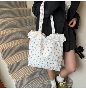Detail of floral canvas tote bag featuring delicate white lace trim on the edges