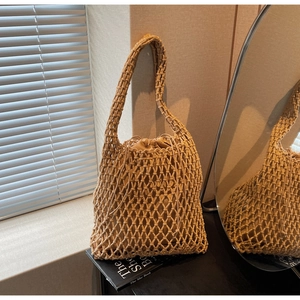 Detail of hand-woven beige hollow mesh bucket bag with a matching drawstring inner pouch