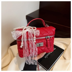 Détail du vanity bag matelassé rouge avec fermoir argenté et nœud en perles