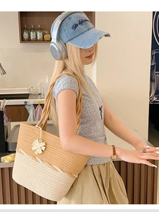 Sac cabas bicolore en paille avec anses en corde et charm floral sur modèle décontracté