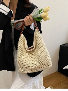 Handmade cream woven straw bucket bag with brown leather strap for beach vacations