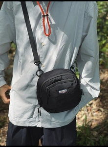 Dettaglio borsa a tracolla in nylon nero antistrappo con logo ricamato e doppie cerniere