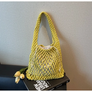 Detailed macro view of yellow macrame bucket bag with cream drawstring canvas inner pouch