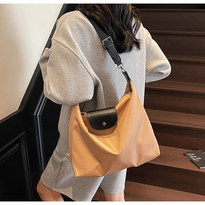 Close-up of lightweight nylon tote with leather flap and adjustable shoulder strap