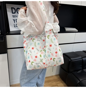 Close-up of floral print canvas tote bag with delicate white lace trim and sturdy handles