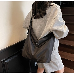 Model wearing a large black nylon hobo crossbody bag for daily casual use