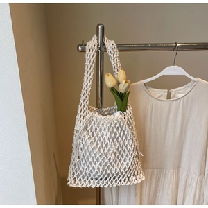 Close-up of woven net bucket bag with drawstring liner and chic hollow knit texture