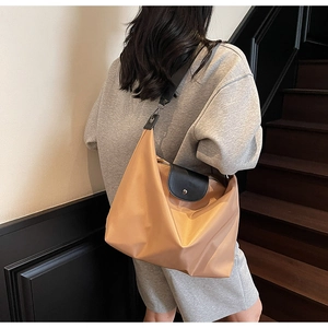 Detail of khaki oxford tote bag with black leather trim and smooth nylon texture