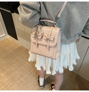 Gros plan d'un mini sac à dos rose brillant avec double nœud et chaîne en perles
