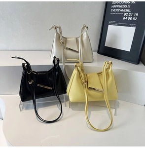 Drei elegante Unterarmtaschen in Weiß, Schwarz und Gelb mit goldenen Metalldetails